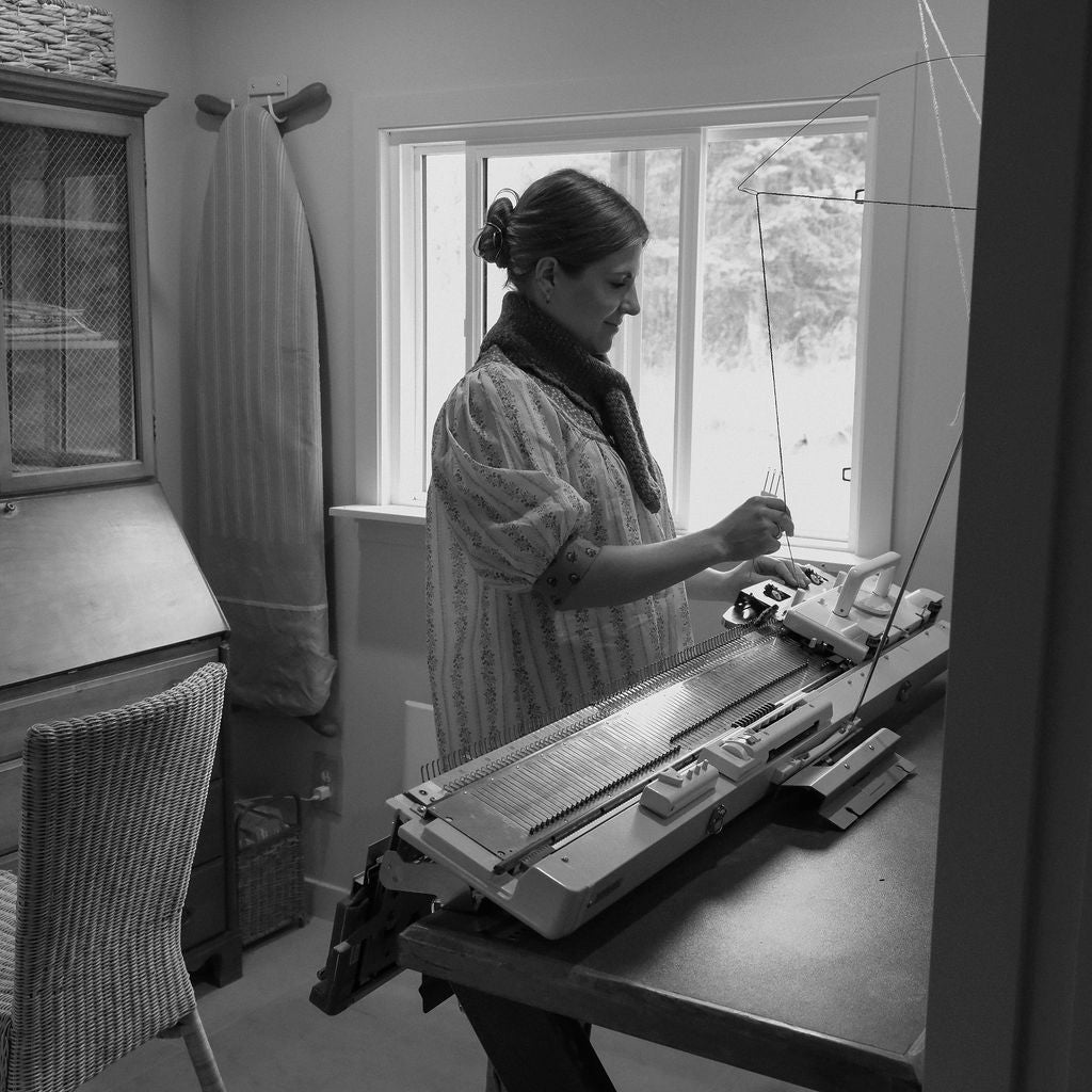 Jillian Barvir knitting on a flatbed manual knitting machine